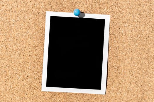 Blank Vintage instant photo frame pinned on corkboard. Template