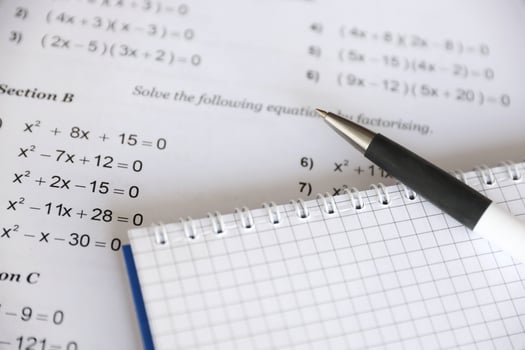 Handwriting of mathematics quadratic equation on examination, practice, quiz or test in maths class. Solving exponential equations concept. photo