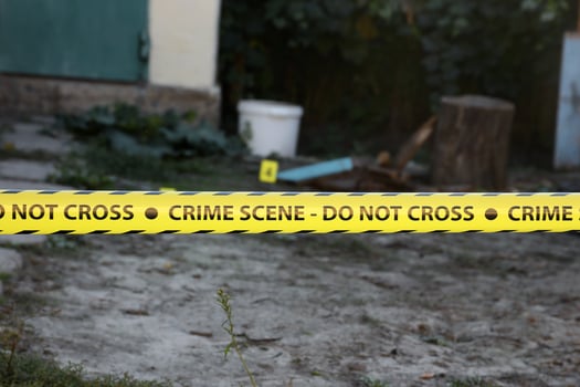 Crime scene tape for covering the area cordon. Yellow tape with blurred forensic law enforcement background in cinematic tone photo