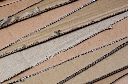 Background image with a lot of beige cardboard paper, which is used to make boxes for the transport of home appliances and postal parcels. Carton texture photo