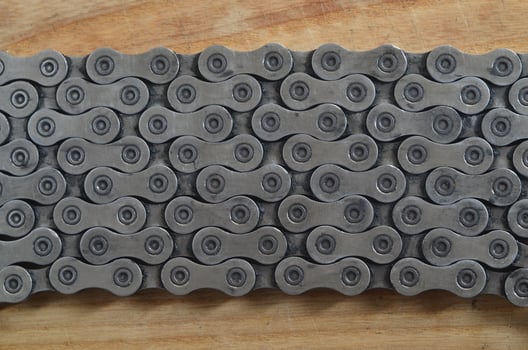 Dirty and oily chain from a mountain bike lying on a wooden table in a bicycle shop photo