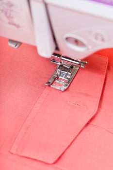 attaching pocket to red shirt on sewing machine photo