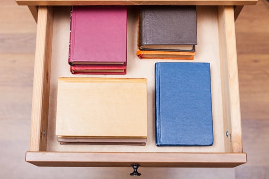 pack ofl little books in open drawer photo
