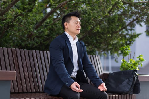 Asian businessman performing breathing exercises trying to calm stress photo
