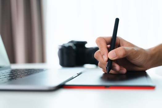 Graphic designer or Photographer use pen mouse drawing and retouch on a tablet board. photo