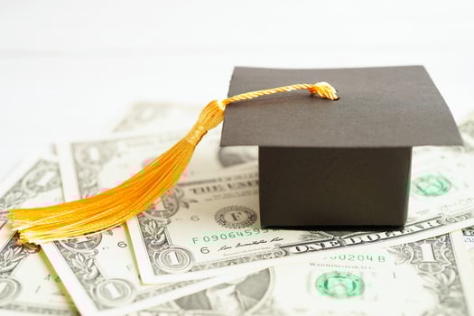 Graduation gap hat on US dollar banknotes money, Education study fee learning teach concept. photo