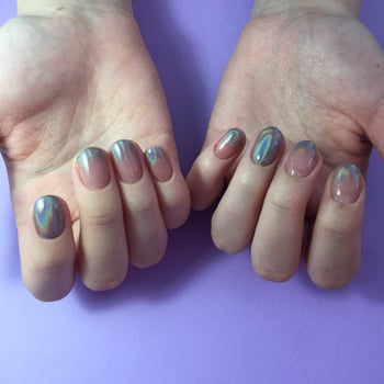 Manicure of different colors on nails. Female manicure on the hand on blue background photo