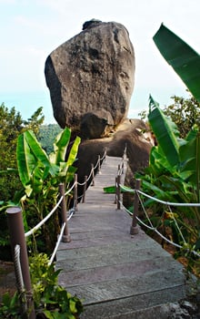 Overlap Stone, large stone and a wooden path to it among tropical vegetation. Thailand, Koh Samui photo