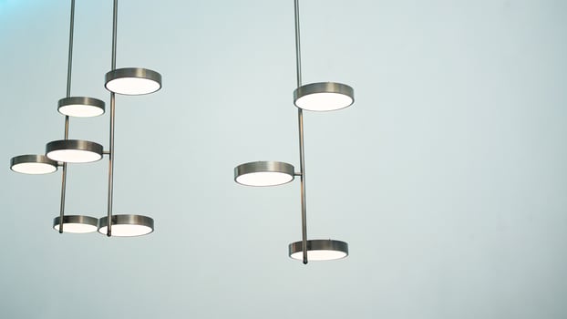 A silver metal lamp in cylinder shape hangs on the ceiling. photo
