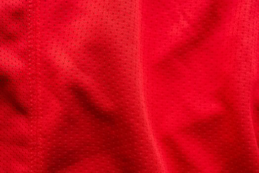 Red fabric sport clothing football jersey with air mesh texture background photo