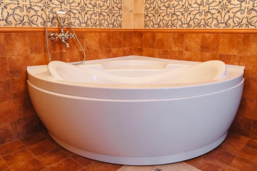 Big white bathtub in a middle of industrial loft bathroom style with grunge cement wall. photo