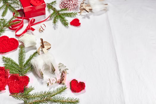 Christmas background with gift boxes, ribbon, twine, paper rolls, knitted hearts and Christmas ornament. photo