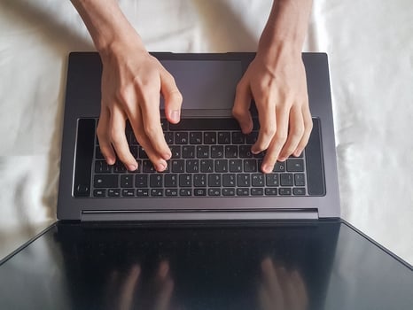 Male hands typing on laptop keyboard photo