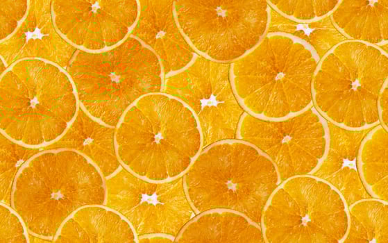 Orange slices seamless background. Cut yellow citrus fruit. photo