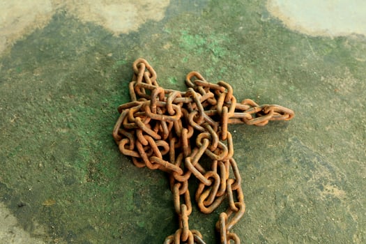 Rusty and dirty steel chains on cement floor in front of the house for locking valuable assets such as motorcycles and bicycles to prevent guerrilla theft. photo