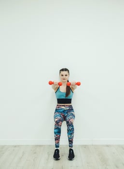 Woman in sport equipment with hand weights photo