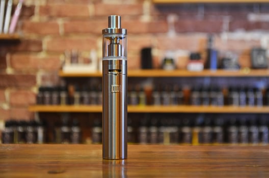 Electronic cigarette on a background of vape shop. E-cigarette for vaping. photo