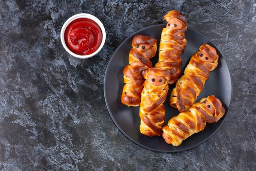 Scary sausage mummies in dough for kids party. Funny crazy Halloween food for children. photo