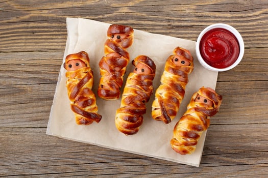 Scary sausage mummies in dough for kids party. Funny crazy Halloween food for children. photo