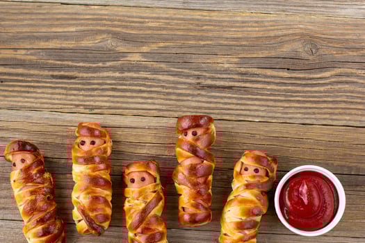 Scary sausage mummies in dough for kids party. Funny crazy Halloween food for children. photo