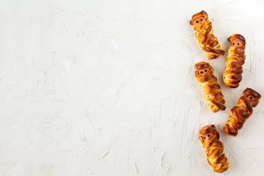 Scary sausage mummies in dough for kids party. Funny crazy Halloween food for children. photo