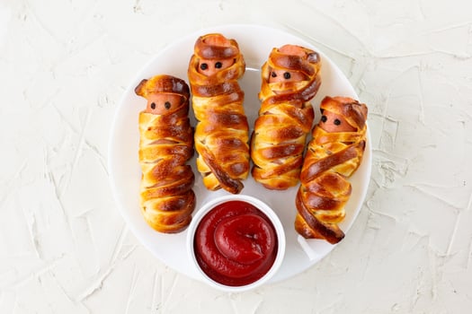 Scary sausage mummies in dough for kids party. Funny crazy Halloween food for children. photo