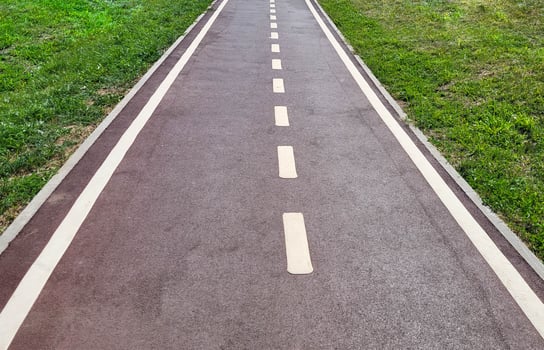 Running road in the middle of a green lawn photo
