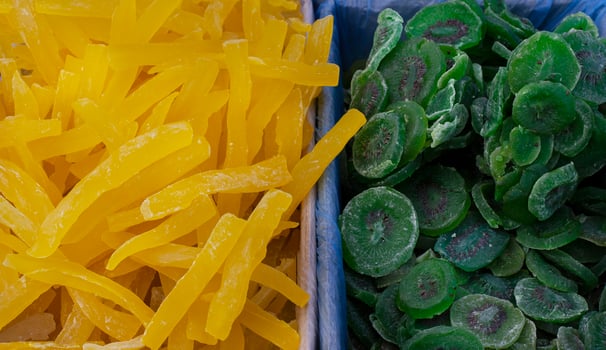 Dried fruits melon kiwi, pile of candied slices in boxes at the market photo