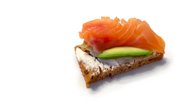Healthy food, cereal bread toast with avocado, cream cheese and red salmon on white background, for breakfast or keto diet, copy space photo