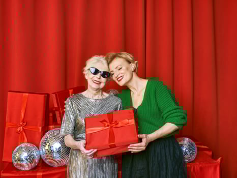 Stylish and fancy senior and mature woman at the party with gift boxes. Party, celebration, technology concept photo