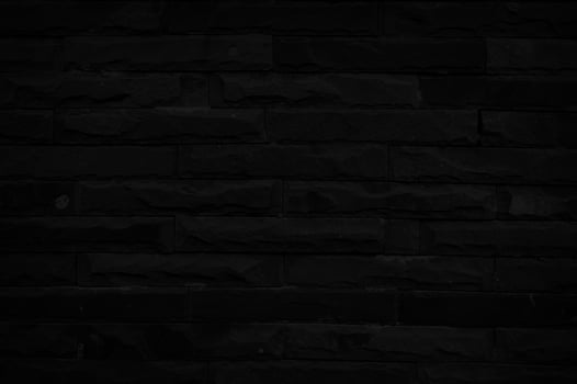 Old black brick wall texture for background with copy space for design. dark wallpaper photo