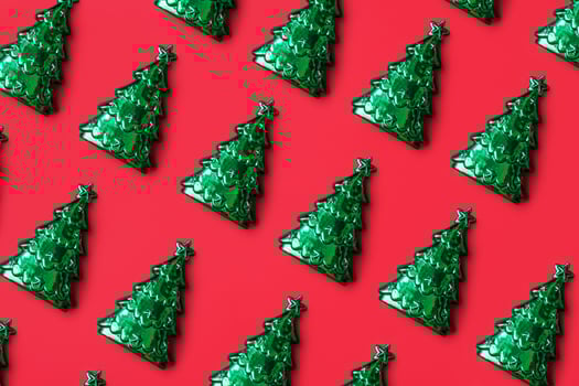 Green Christmas tree pattern minimal flatlay on red background new year holiday celebration concept photo