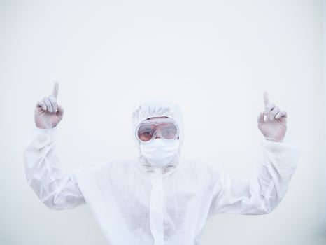 Doctor or scientist in PPE suite uniform showing both hands poiting up to empty space above. coronavirus or COVID-19 concept isolated white background photo