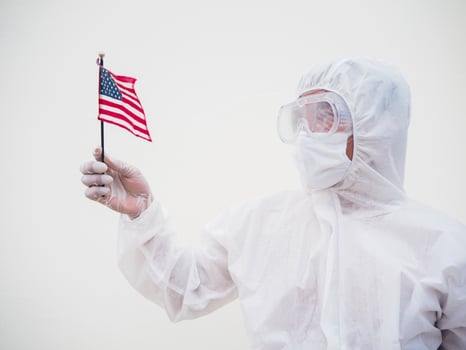 Portrait of doctor or scientist in PPE suite uniform holding national flag of United states of America. COVID-19 concept isolated white background photo