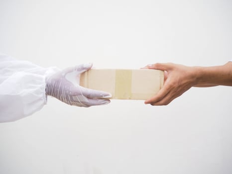 Coronavirus or COVID-19 concept. Protected contact between courier and client during quarantine on white background photo
