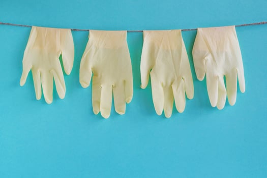 Drying of disposable medical gloves after washing on a rope for reuse, on a turquoise background. Concept of new normal lifestyle. photo