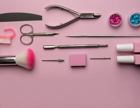 Set of manicure tools and accessories on a pink background. Hardware manicure,Flat lay. photo