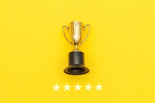 Simply flat lay design winner or champion gold trophy cup and 5 stars rating isolated on pink pastel background. Victory first place of competition. Winning or success concept. Top view copy space. photo