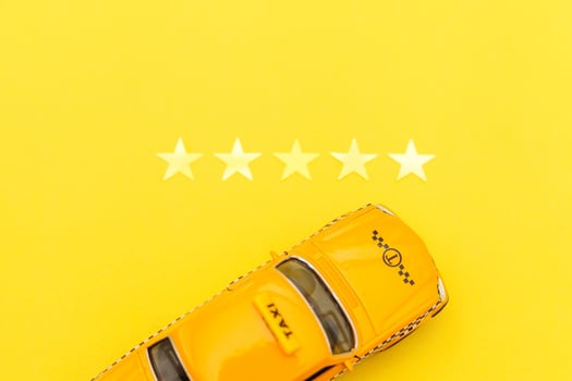 Yellow toy car Taxi Cab and 5 stars rating isolated on yellow background. Smartphone application of taxi service for online searching calling and booking cab concept. Taxi symbol. Copy space. photo