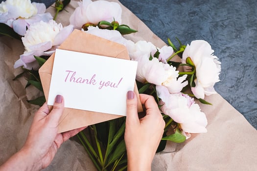 Thank you card in hands, message, envelope, pink peony flowers bouquet photo