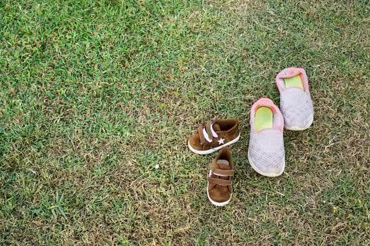 shoes of a mother and child left on the field to play together photo