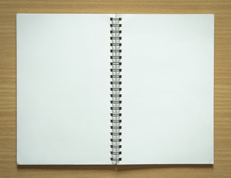 blank spiral notepad on wood background photo