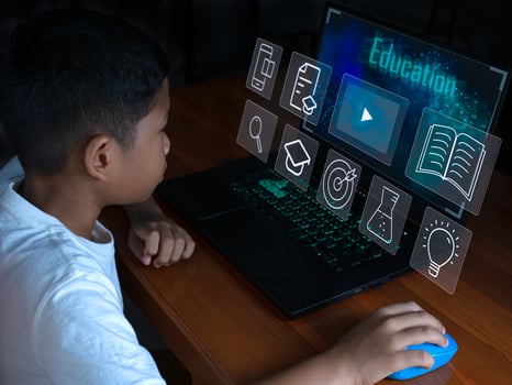 Close up The boy sits staring at the laptop and his hand is holding the mouse. educational concept, educational information search, copy space photo