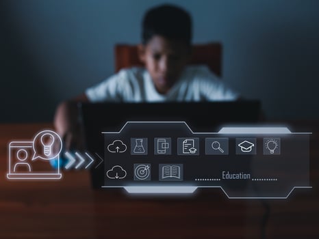 education icon On the background of blurry pictures a boy is staring at a computer monitor. educational concept, educational information search, copy space photo
