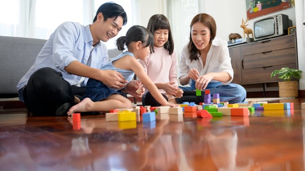 Asian family with children playing and building tower of colorful wooden toy blocks in living room at home, Educational game. photo