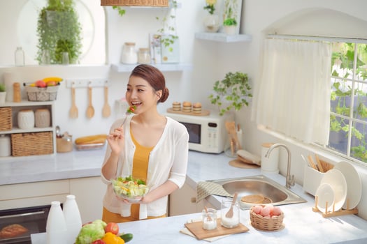 Close up portrait of cute girl eating salad on kitchen photo