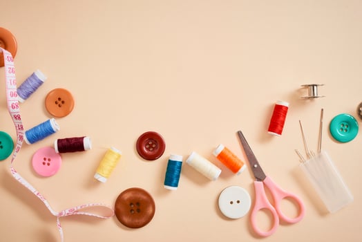 tools for needlework thread scissors and tape measure isolated on biege background photo