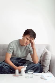 man with headache having in front warm water glass and pills photo