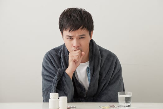 Sick man lying on bed and coughing a lot photo