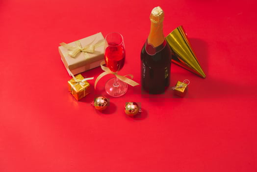 Champagne and Christmas ornaments on red table  background photo